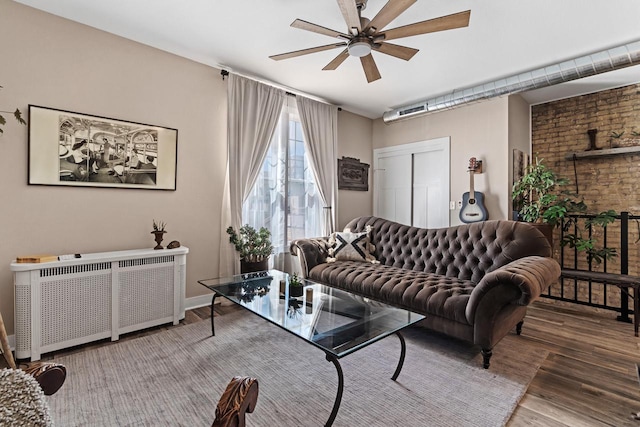 living room with ceiling fan, hardwood / wood-style floors, and radiator heating unit