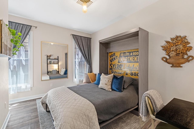 bedroom with multiple windows and wood-type flooring