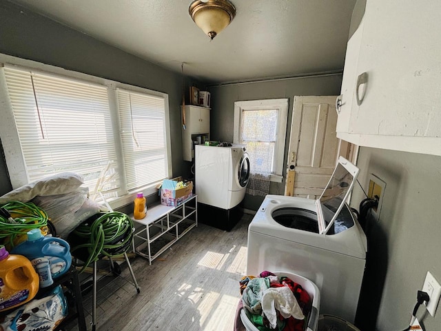 laundry area featuring cabinets, wood-type flooring, washer and clothes dryer, and water heater