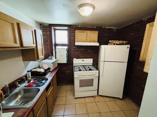 kitchen featuring sink, light tile patterned floors, brick wall, and white appliances