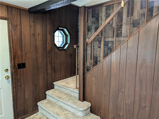 stairs featuring wood walls