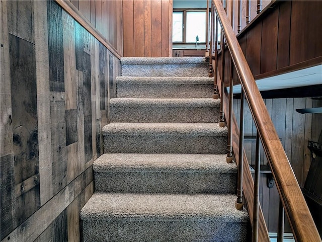 stairway featuring wood walls