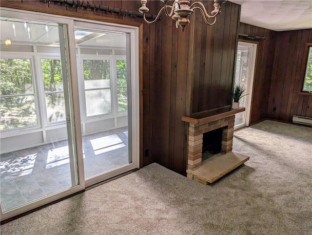 interior space featuring a notable chandelier, wood walls, plenty of natural light, and carpet floors