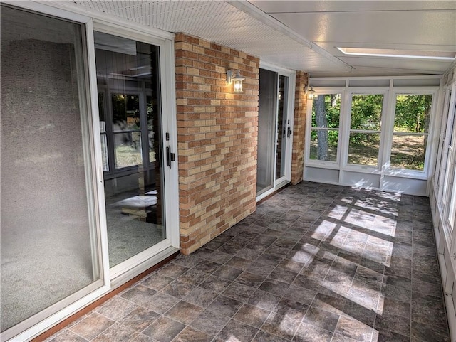 unfurnished sunroom featuring a skylight