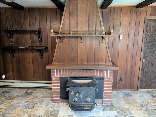 room details featuring a wood stove, wood walls, and baseboard heating