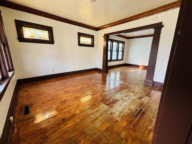 empty room with crown molding and hardwood / wood-style floors