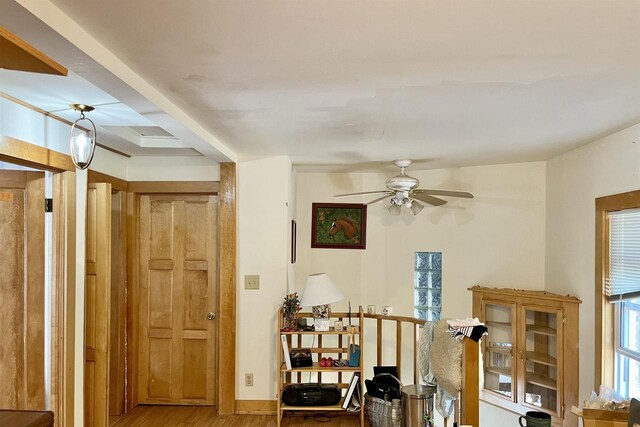 interior space featuring ceiling fan, beam ceiling, and hardwood / wood-style floors