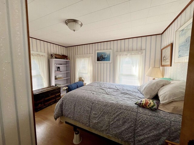 bedroom with wood-type flooring and crown molding