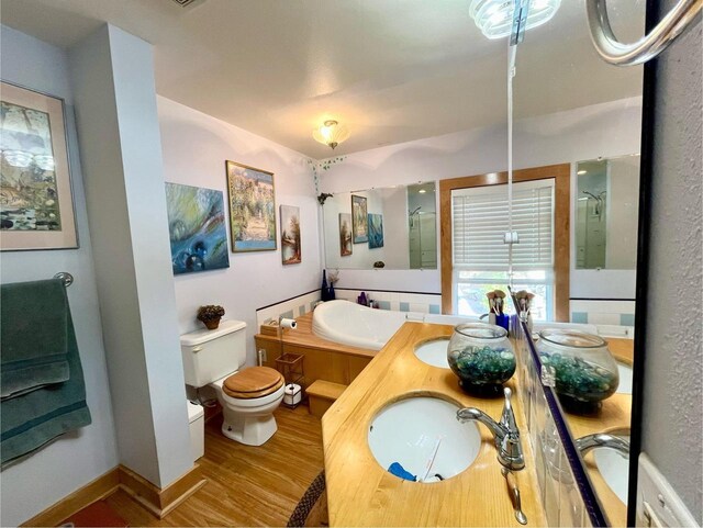 full bathroom with shower with separate bathtub, vanity, toilet, and hardwood / wood-style floors