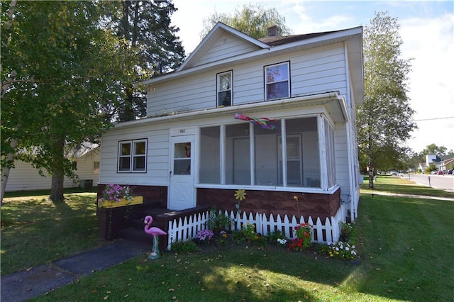 view of front of home featuring a front lawn and a sunroom