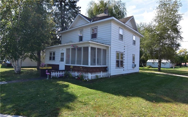 back of property featuring a lawn and a sunroom