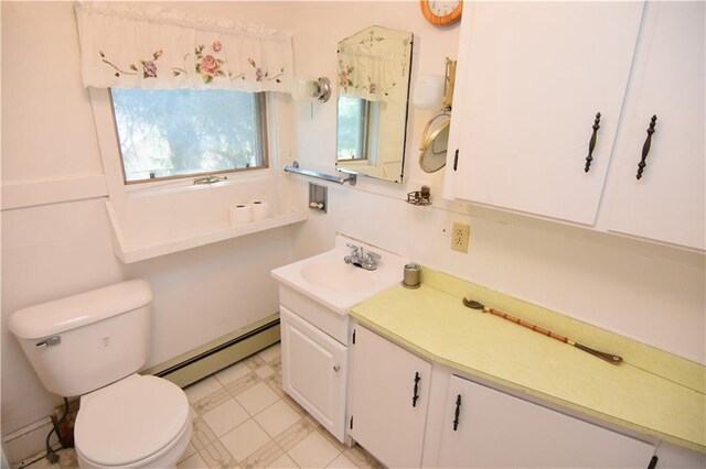 bathroom featuring vanity, toilet, and a baseboard heating unit