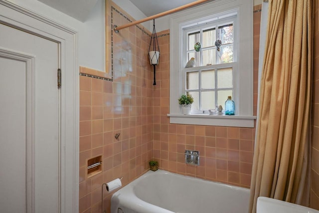 bathroom with shower / tub combo with curtain and tile walls