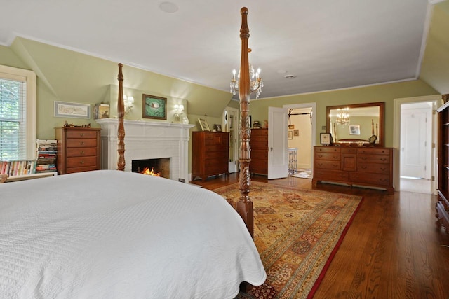 bedroom featuring vaulted ceiling, dark hardwood / wood-style floors, a brick fireplace, and a notable chandelier