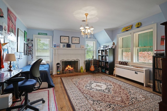 office featuring ornamental molding, hardwood / wood-style floors, a chandelier, and a brick fireplace