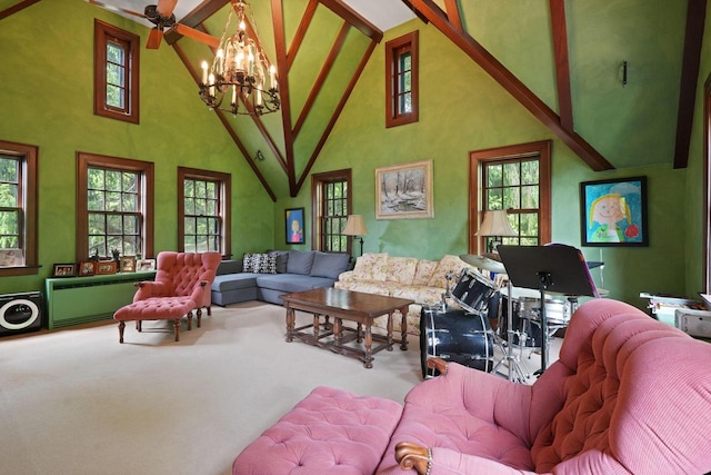 carpeted living room with ceiling fan with notable chandelier and high vaulted ceiling