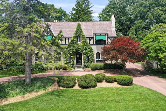 tudor home featuring a front lawn