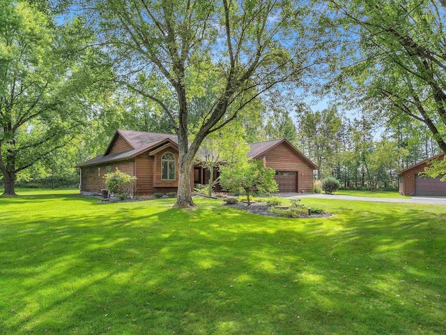 view of front of home with a front lawn, an outdoor structure, and a garage