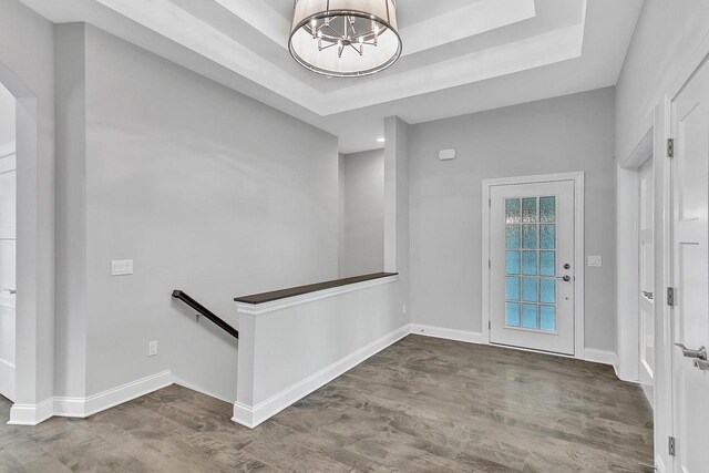 entryway featuring dark hardwood / wood-style floors, a chandelier, and a tray ceiling