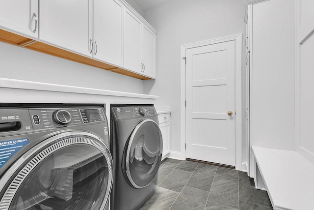 laundry room featuring cabinets and washing machine and clothes dryer