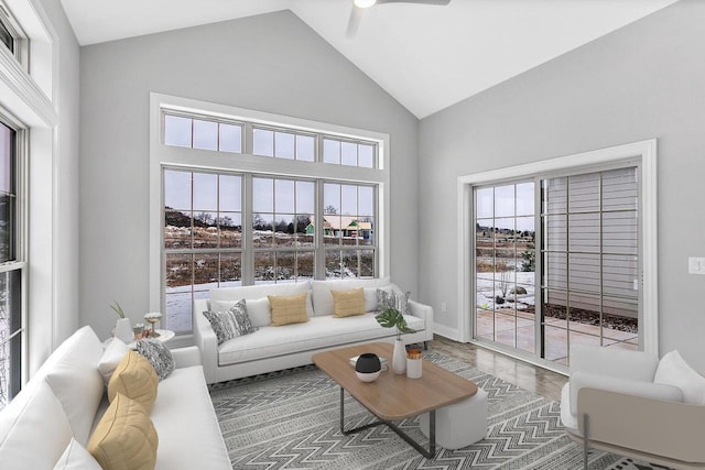 living room with hardwood / wood-style flooring, ceiling fan, and high vaulted ceiling