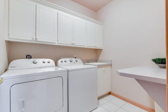 washroom with cabinets, independent washer and dryer, light tile patterned floors, and sink