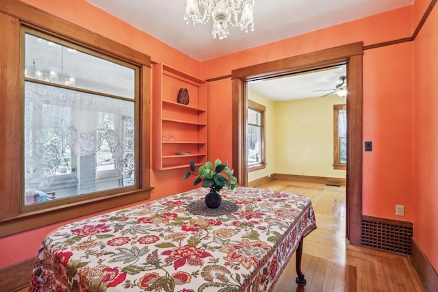 bedroom with light wood-type flooring and a chandelier