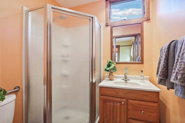 bathroom featuring walk in shower, vanity, and toilet