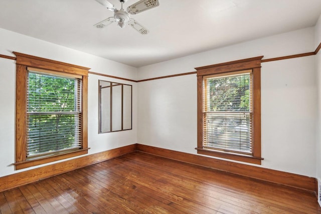 unfurnished room with a wealth of natural light, wood-type flooring, and ceiling fan