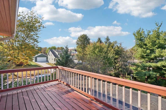 wooden deck featuring a garage and an outbuilding