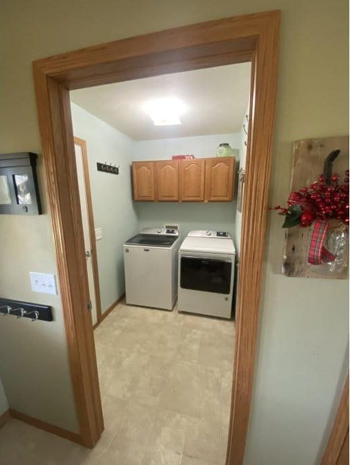 laundry area with cabinets and washing machine and dryer