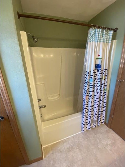 bathroom featuring shower / tub combo with curtain and tile patterned flooring