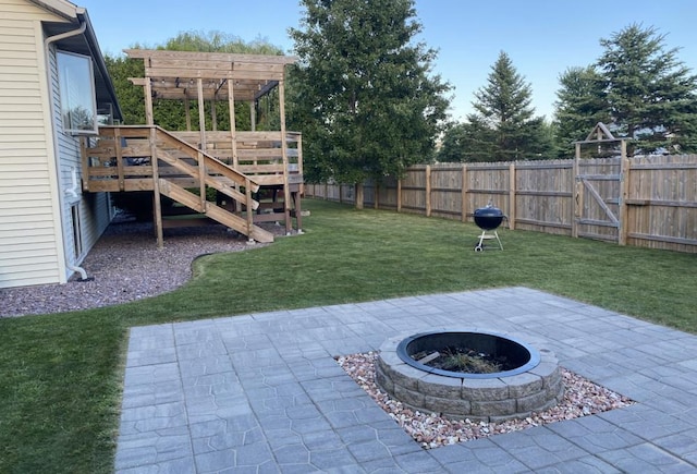 view of yard with a wooden deck, a patio area, and an outdoor fire pit