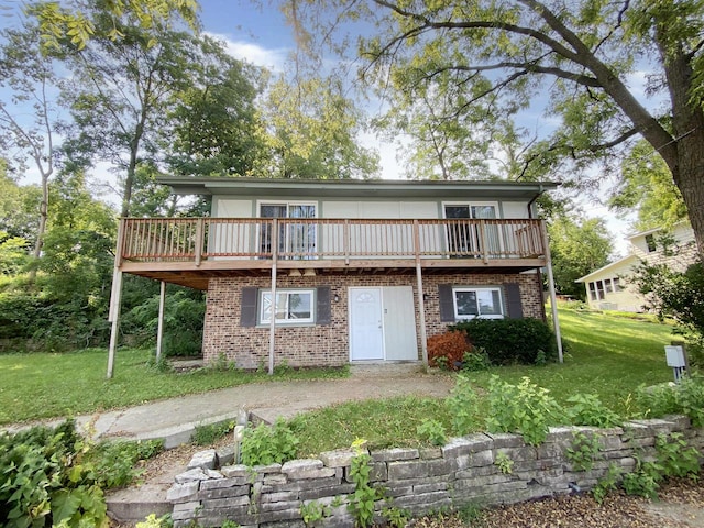 rear view of house featuring a lawn and a wooden deck