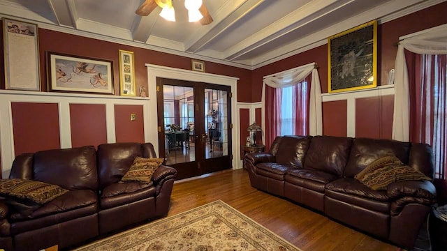 living room featuring a ceiling fan, ornamental molding, wood finished floors, beamed ceiling, and french doors