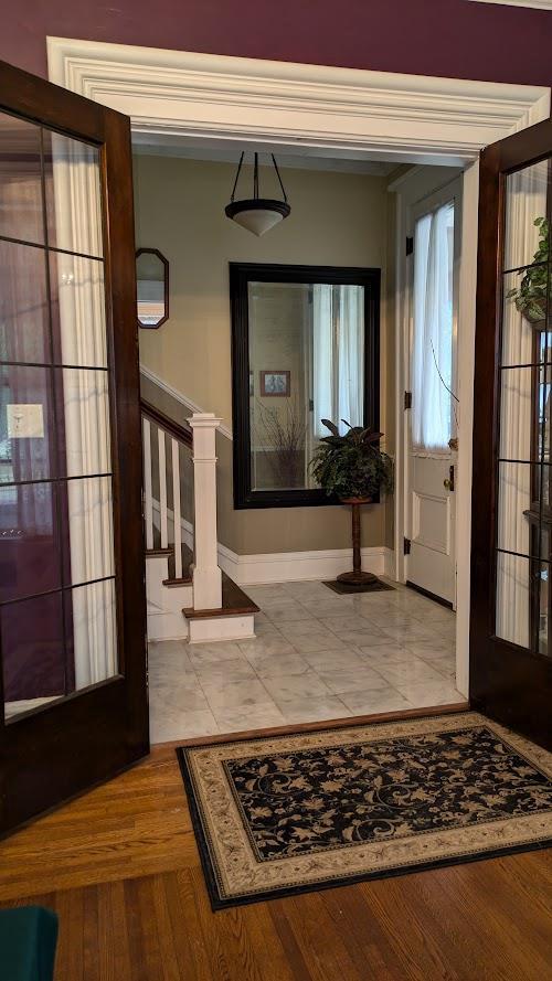 foyer with stairs, wood finished floors, and baseboards