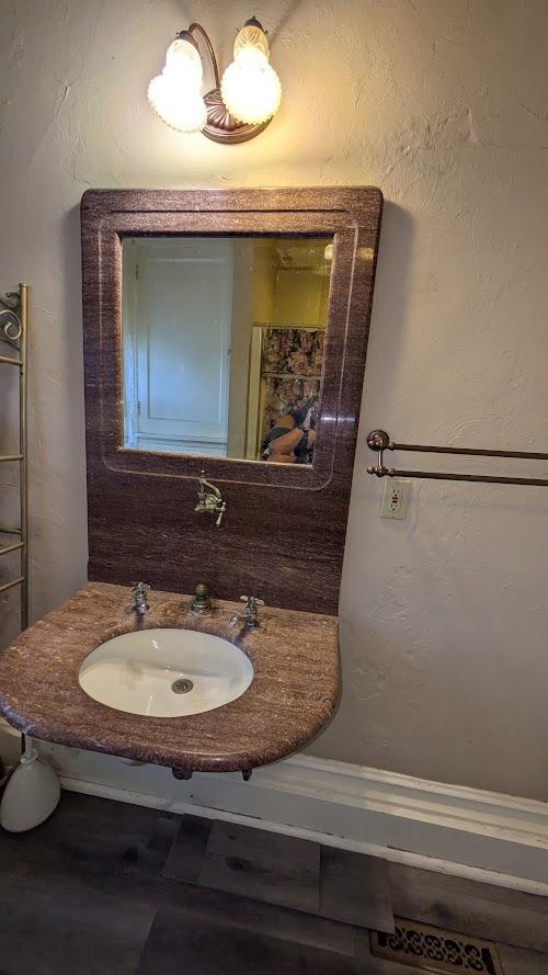 bathroom featuring a textured wall and a sink