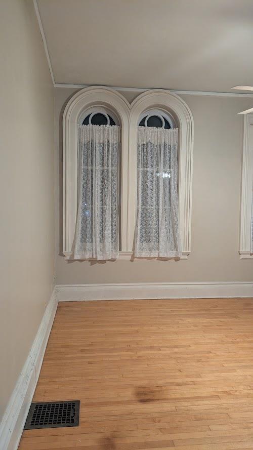 interior space with visible vents, baseboards, and wood finished floors