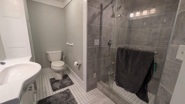 full bath featuring toilet, a shower stall, vanity, baseboards, and tile patterned floors