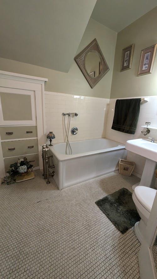 full bathroom featuring tile patterned flooring, a garden tub, tile walls, and toilet