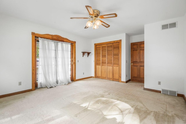 unfurnished bedroom featuring light carpet, a closet, and ceiling fan