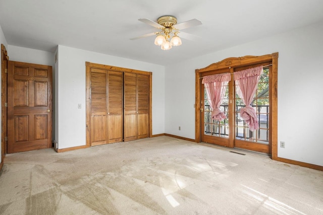 unfurnished bedroom featuring a closet, ceiling fan, light colored carpet, and access to exterior