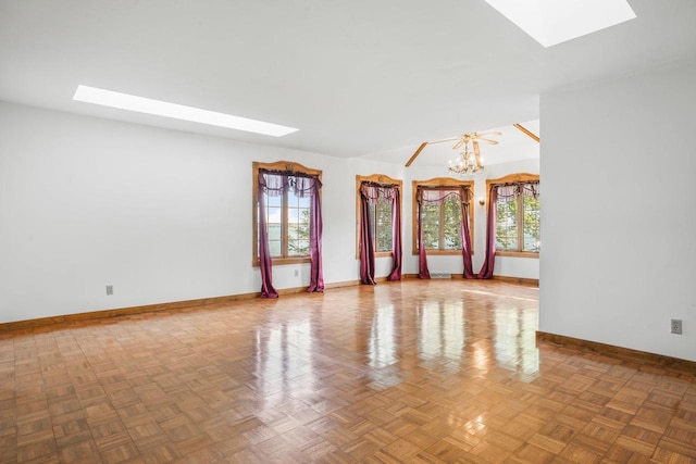 empty room with an inviting chandelier, parquet flooring, and a wealth of natural light