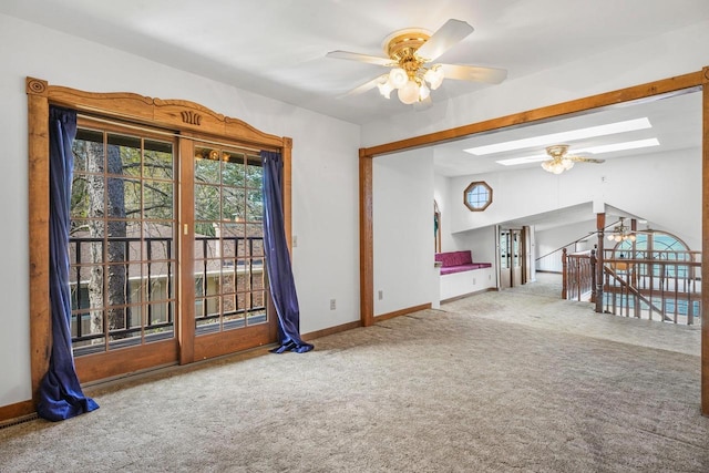 spare room with carpet, ceiling fan, and a skylight