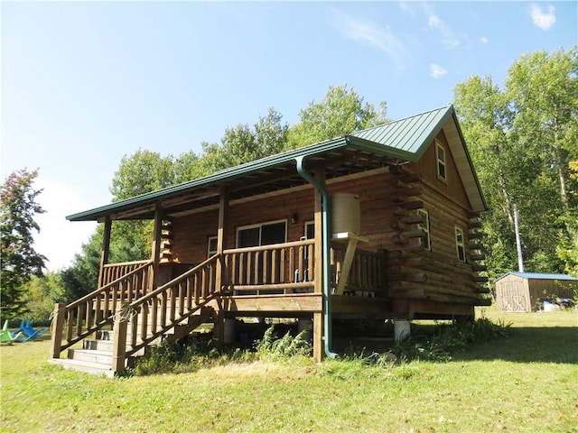 log home featuring a shed and a front lawn