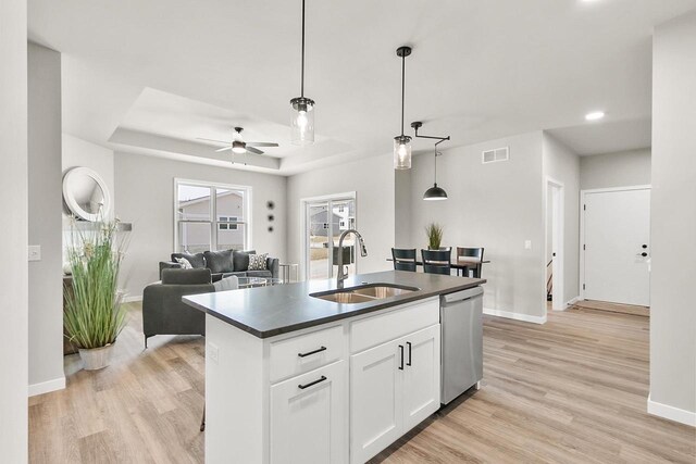 2876 Wild Goose Way, Stoughton, WI 53589 - kitchen with dark countertops, a raised ceiling, a sink, open floor plan, and stainless steel dishwasher