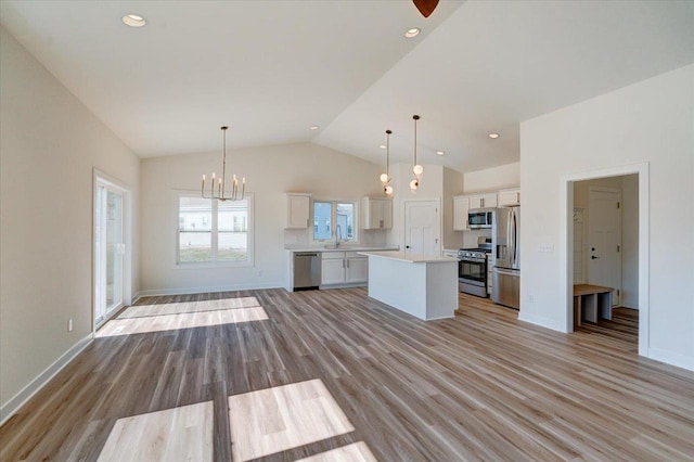 kitchen featuring white cabinets, pendant lighting, light hardwood / wood-style flooring, appliances with stainless steel finishes, and a center island