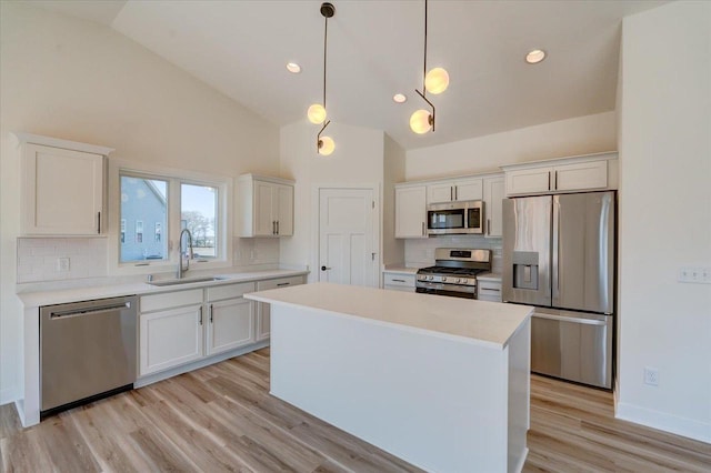 kitchen with stainless steel appliances, hanging light fixtures, and white cabinets