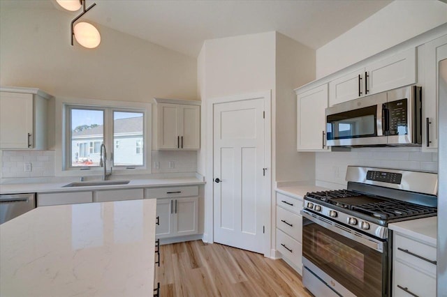 kitchen featuring white cabinetry, sink, stainless steel appliances, and backsplash