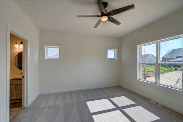 empty room with ceiling fan and light carpet